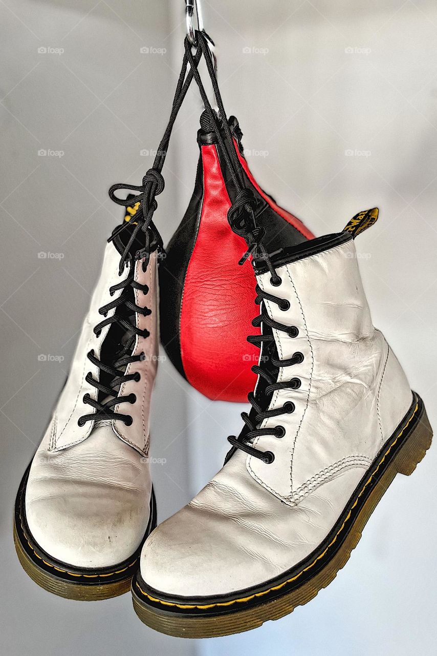 Doc Marten boots with speed bag, boxing and Docs, sports and Dr. Martens, versatile boots, Doc Marten white boots hung around speed bag, punching bag and Docs, getting creative with DMs, Doc Marten boot advertising, product placement for advertising 