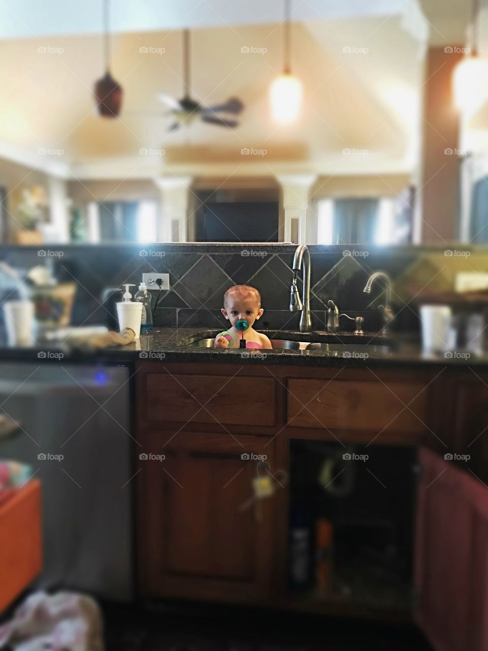 Tiny baby in sink of huge kitchen