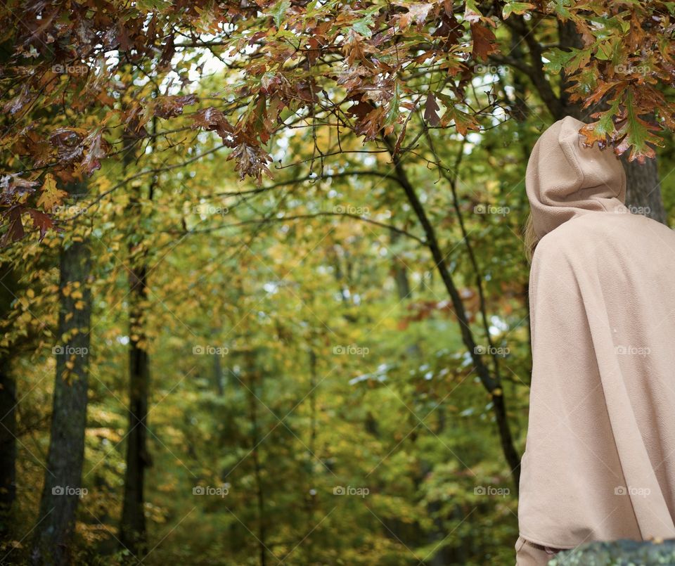Rainy Fall Daze: Woman in Hooded Cloak walking among a Autumn wonderland and wet turning leaves