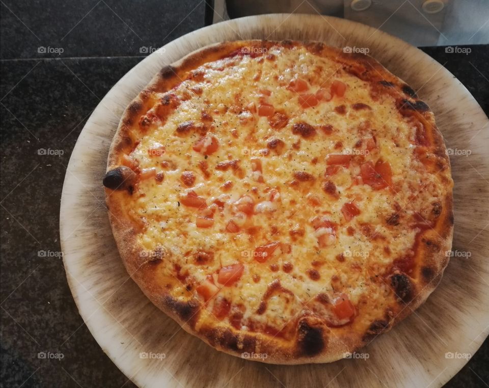 pizza margaritafrom wood fired oven on cutting board