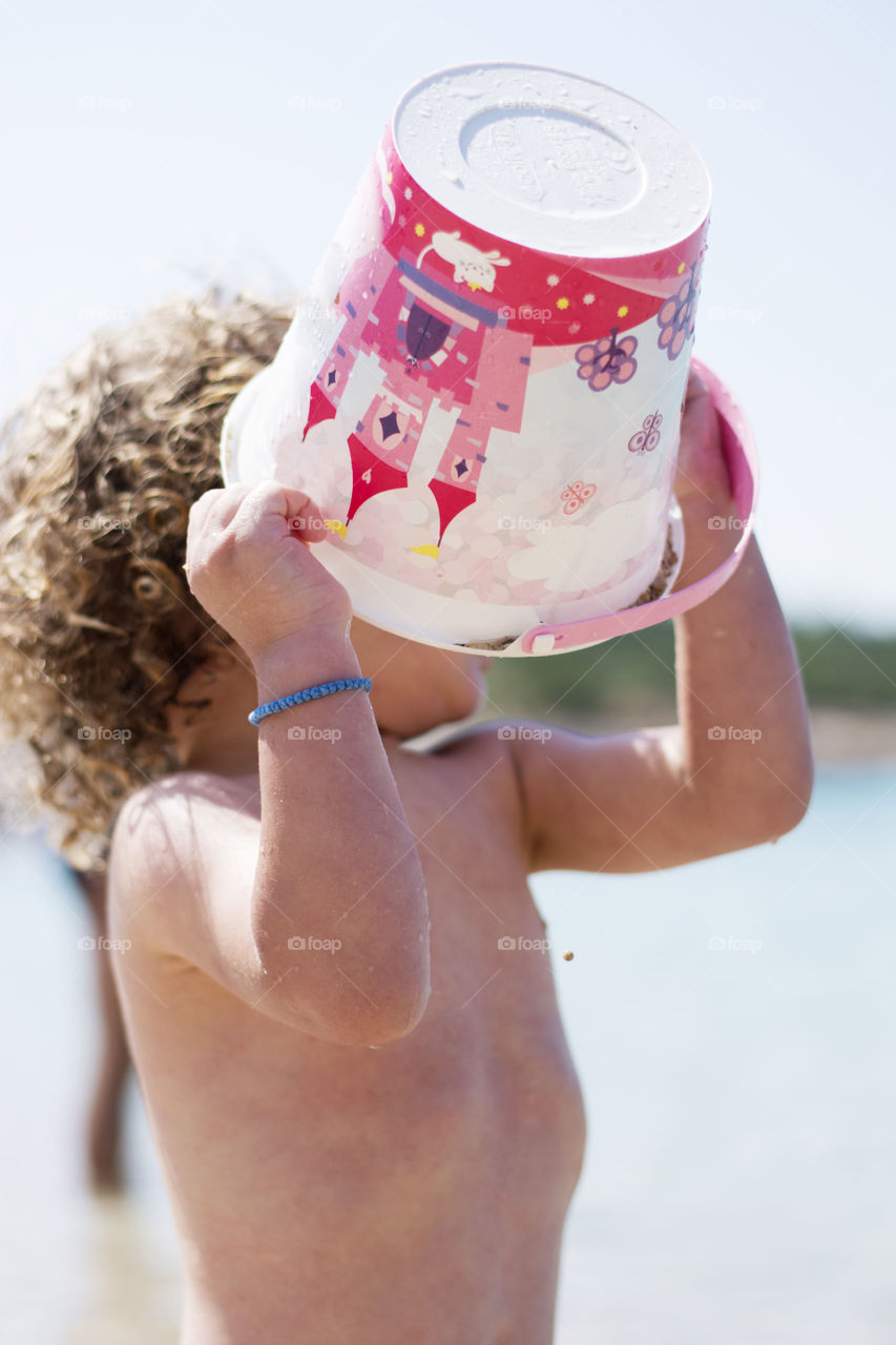 kid is playing on the beach. kid playing with sand on the beach