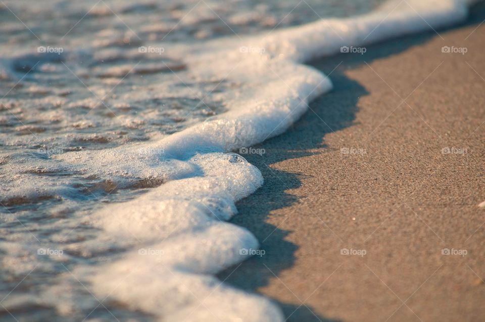 Waves roll on to the beach as the sun sets in Hollywood Beach, Florida. 