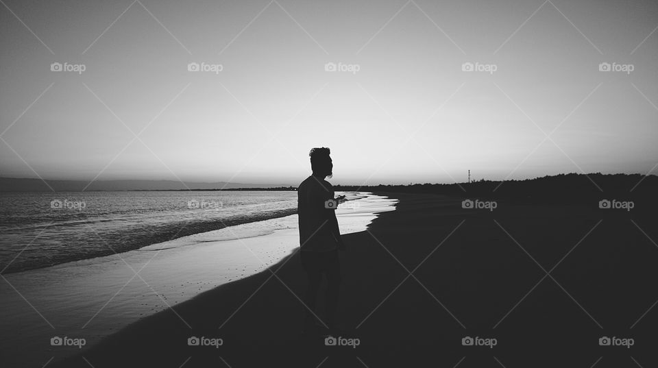 Man standing along the seashore.