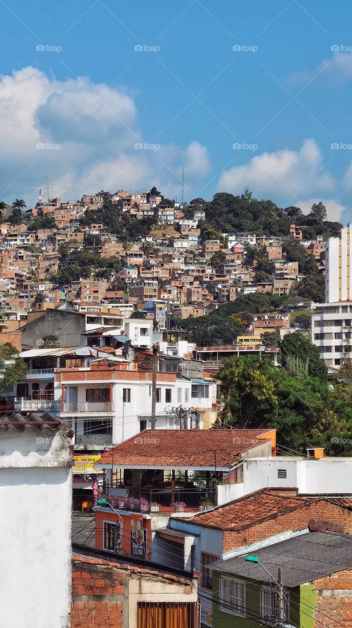 Cityscape in Santiago de Cali, Colombia, view from a balcony. Sunny and clear day. Building over the mountain