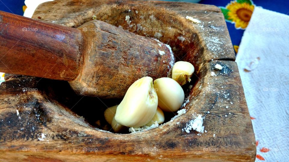 Pilão e mão-de-pilão para amassar alho. Tempero na cozinha.