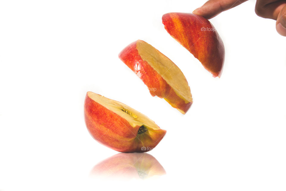 Hand with apple slice on white background