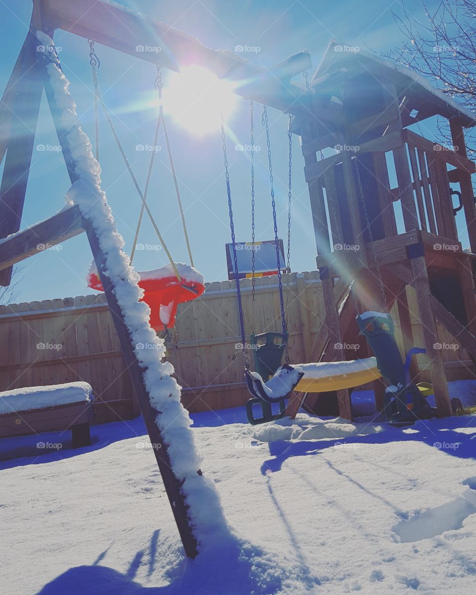 with winter approaching it's time to get ready for the snow. here is a picture with a swing set covered in snow and the warm sun beaming down