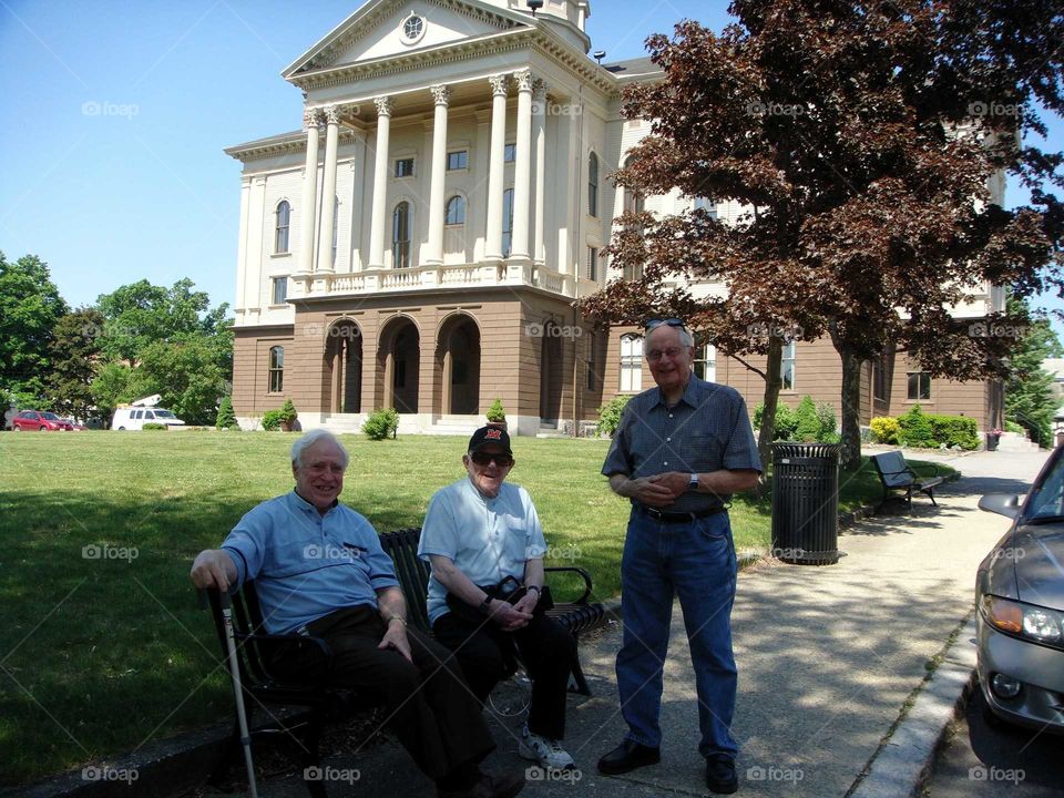Men in front of refurbished Town Hall to its original colors, New England.