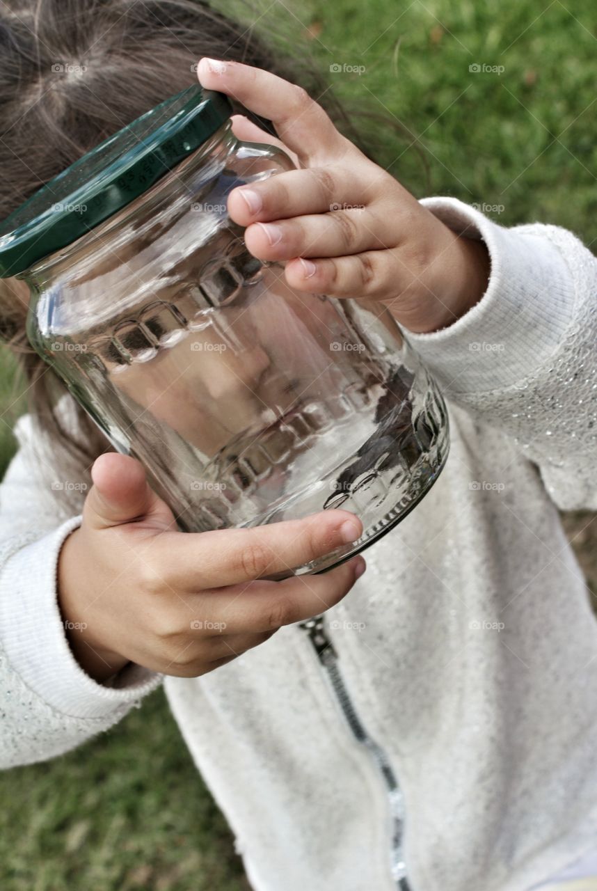 Little girl holding a jar with bugs