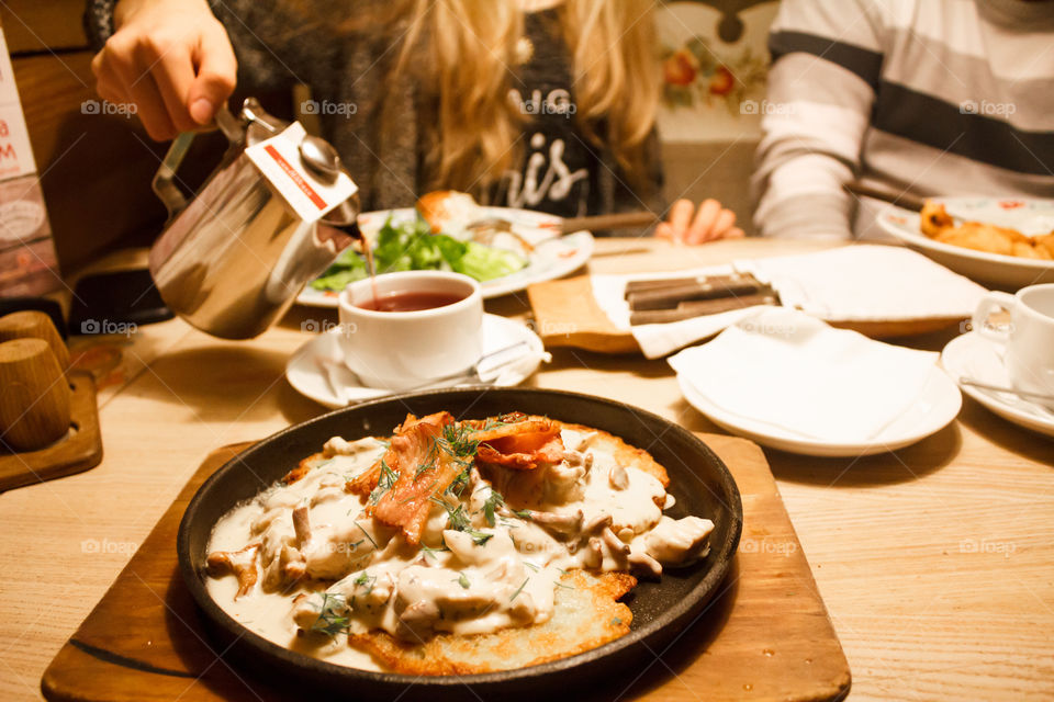 a hot dish on a frying pan and a cup of tea