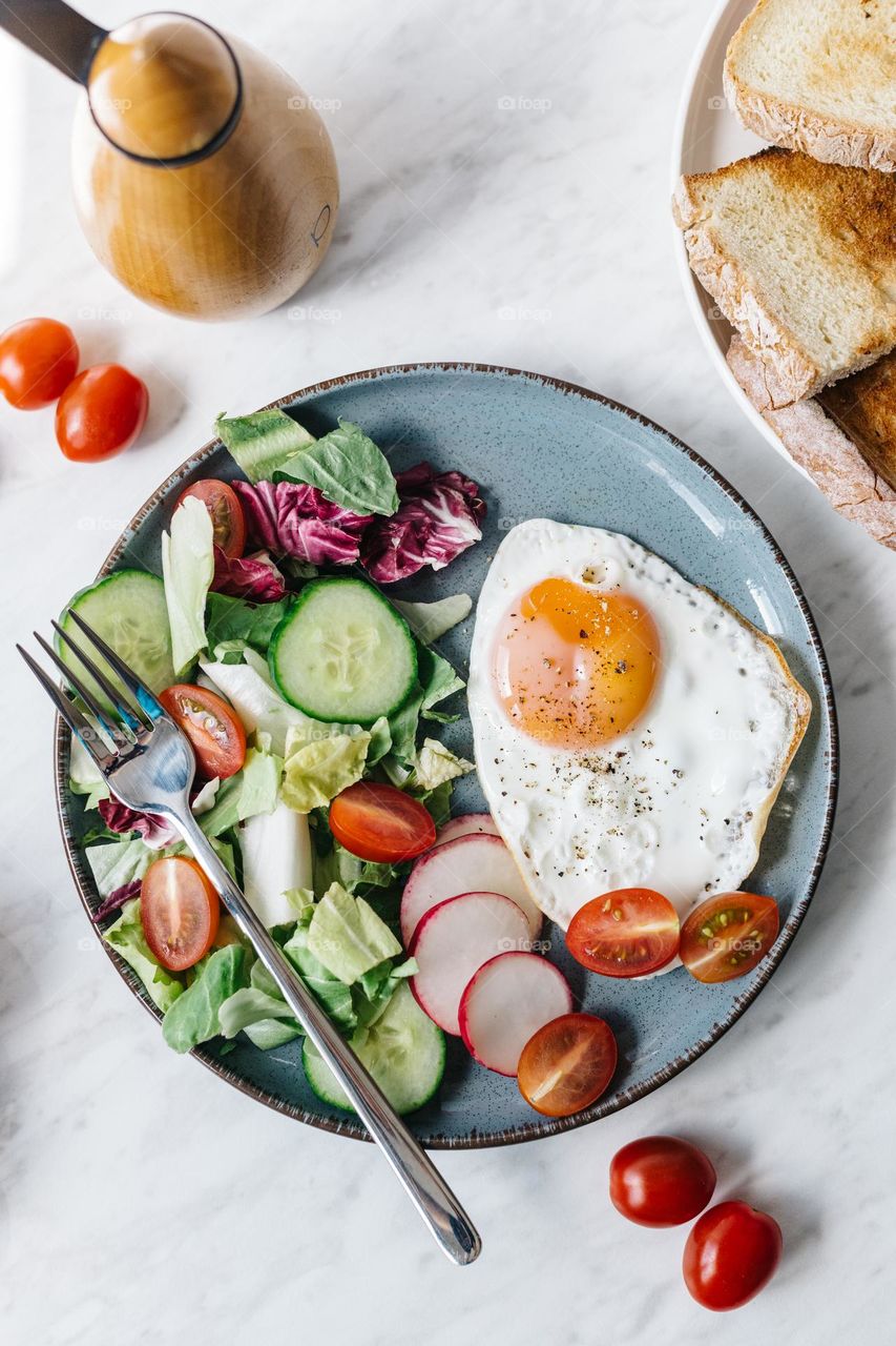 Healthy breakfast with eggs, veggies and bread.