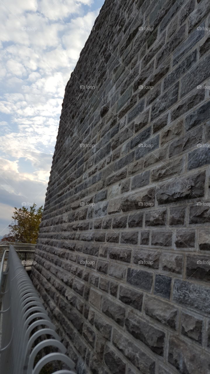 Stone wall against cloudy sky