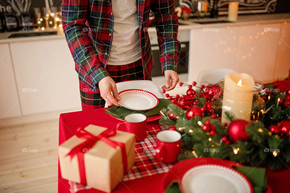 man sets a beautiful decorated winter table for a festive dinner.  Merry Christmas and Happy New Year.