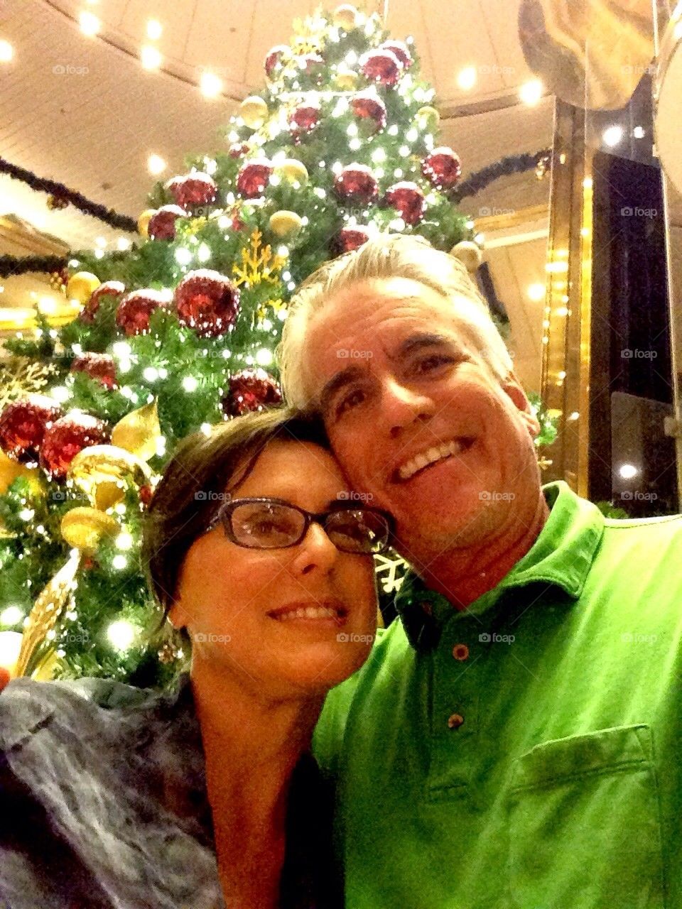 Couple getting picture by Christmas tree