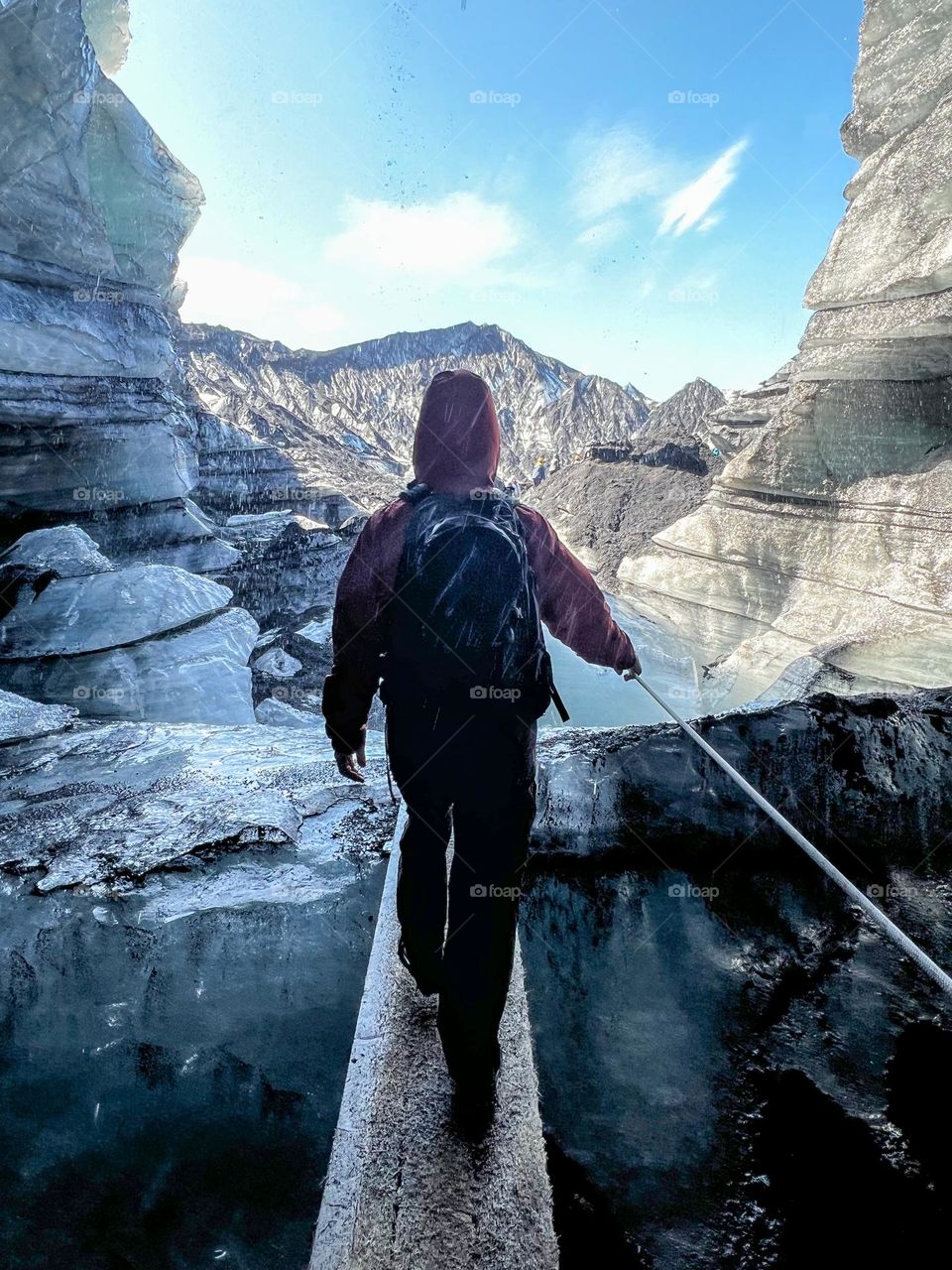 Walking through an ice cave into the sunshine