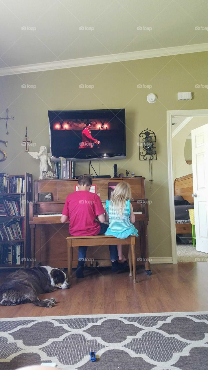 Brother and sister Playing Piano with dog