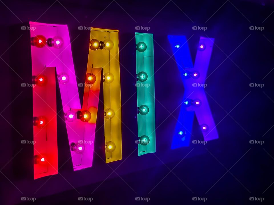 Colorful neon style sign in the colors of the rainbow spelling the word Mix, glowing in the night 