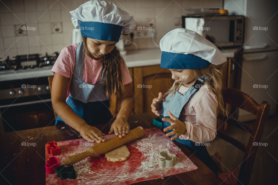 Little sisters cooking the biscuits 