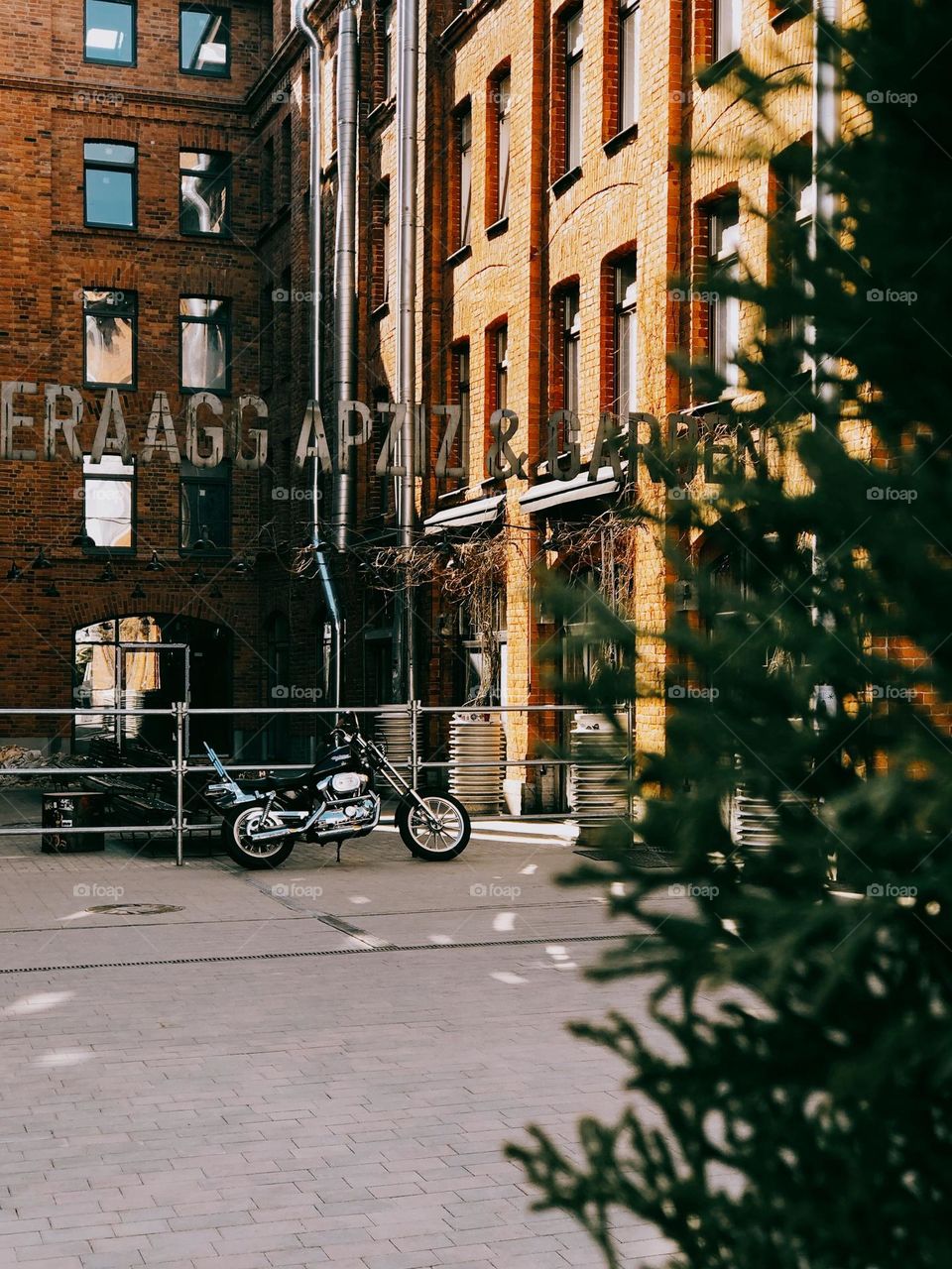 Lonely modern motorcycle standing near modern cafe on the street in sunny day, nobody 