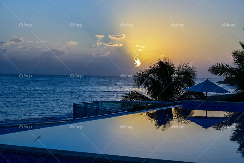 sunrise in the tropics on the beach near swimming pool