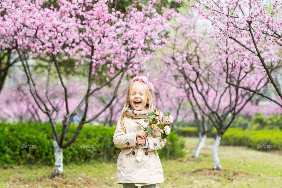 Happy little Caucasian girl laughing outdoor at spring