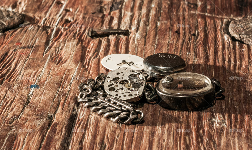 Retro watch parts lying on the wooden table.