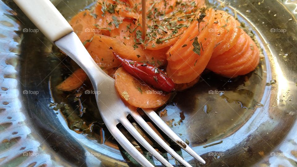 Cenoura crua com pimenta. Garfo e prato.
