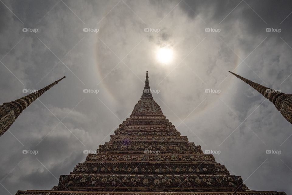 Natural miracle , Halo sun over Beautiful Pagoda at The Temple of  The Reclining Buddha (Wat Pho) in Bangkok Thailand attract tourists attention to excite