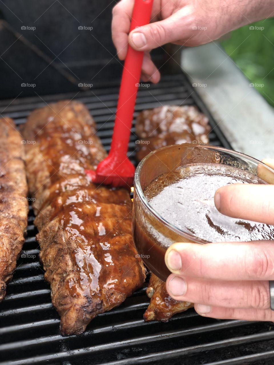 BQ ribs on the grill. These ribs are being basted in homemade BQ sauce. These delicious and tender ribs will melt in your mouth.