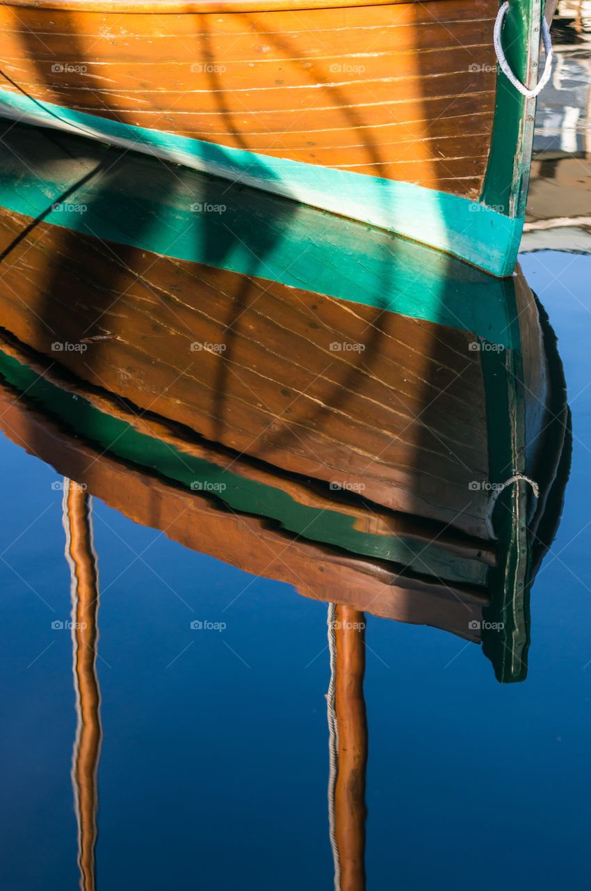 Reflection of a beautiful wood boat in still water.