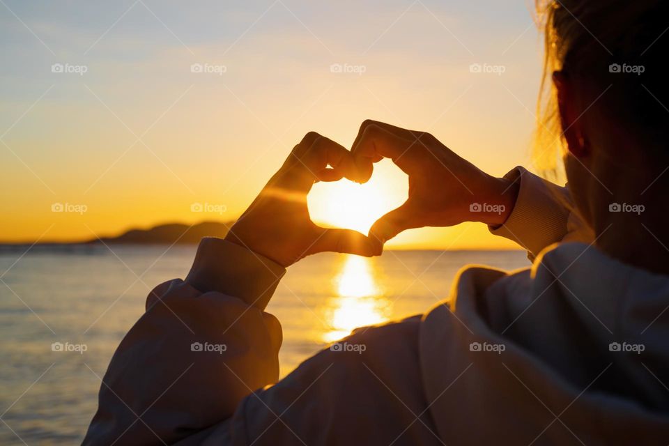 heart shape with hands in sunset