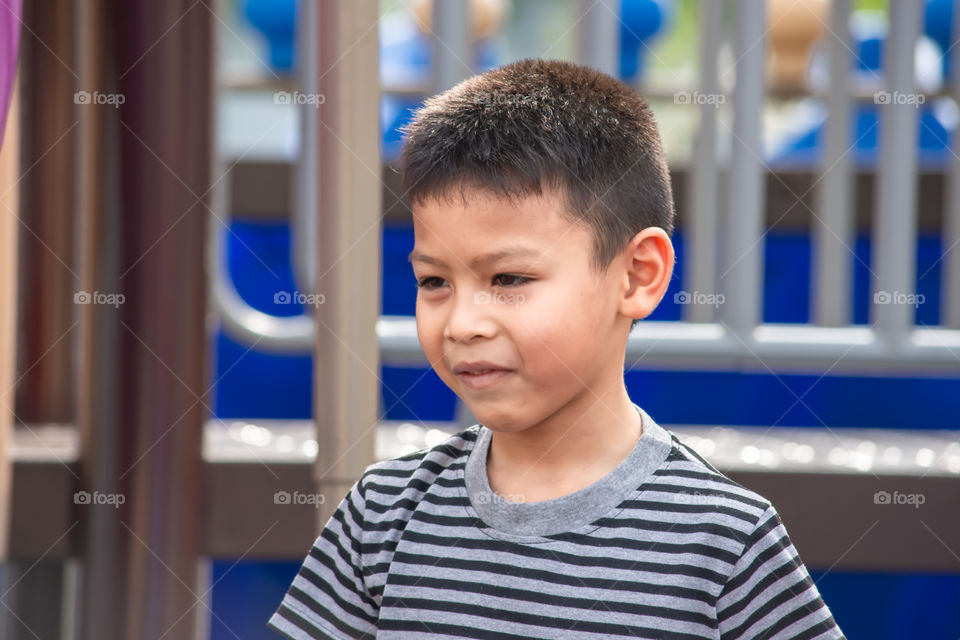 Portrait of a boy Asia, laughing and smiling happily in the playground.