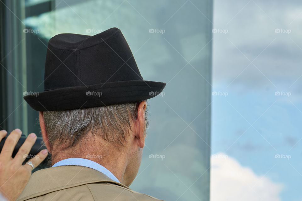 Elderly man looking through the window