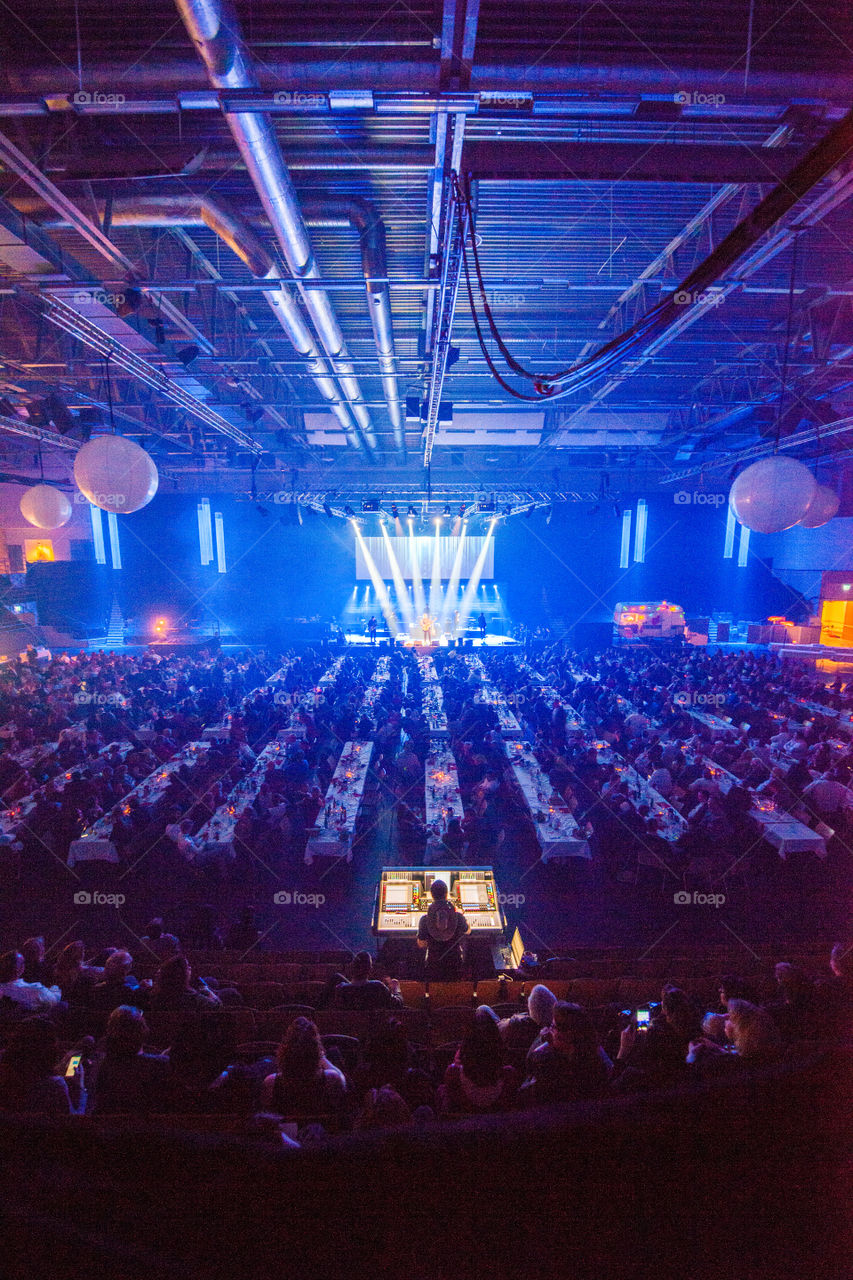 A large corporate event with live performers and various appearances in a large arena.