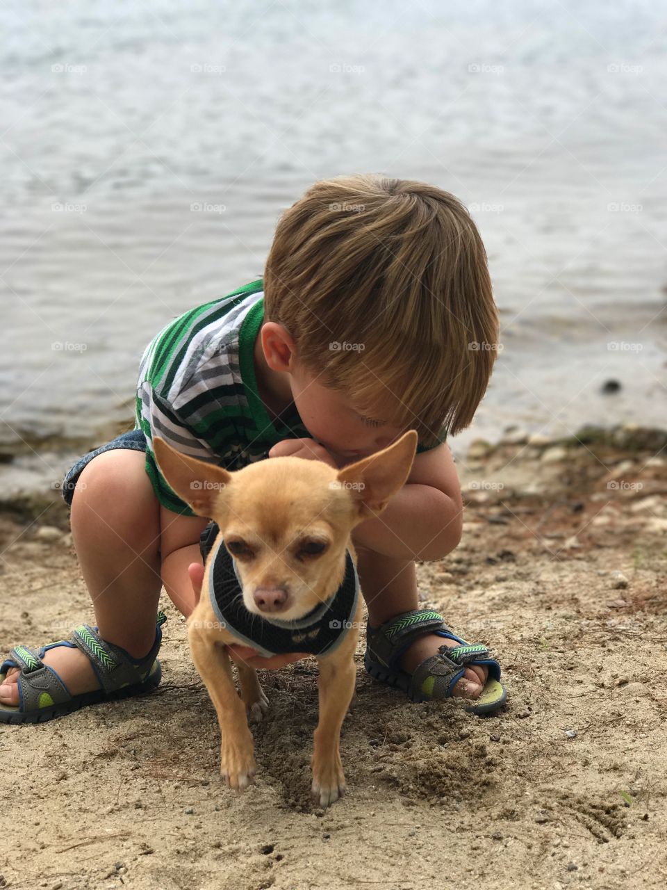 Little boy hugging his dog with tons of love
