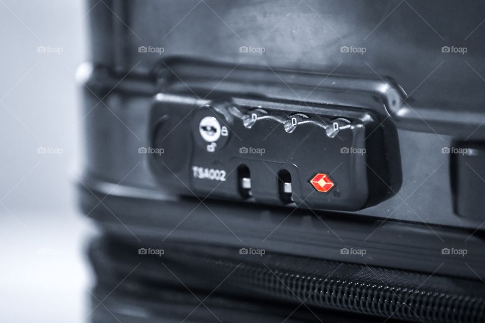Suitcase in colorsplash. Focus on TSA approved combination lock.