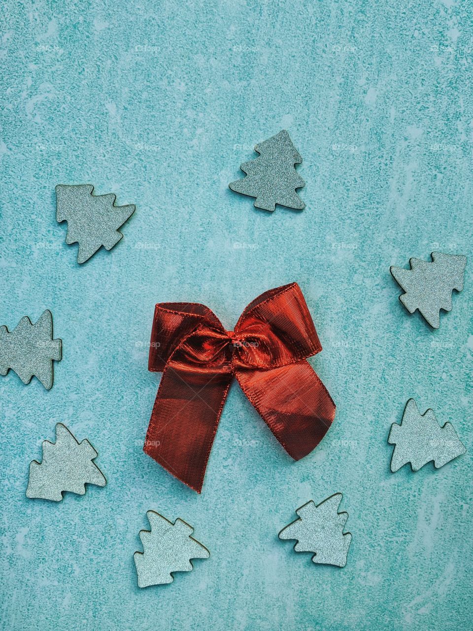 Christmas or New Year composition. Red bow with festive decor on a light blue background. Top view. Flat lay.