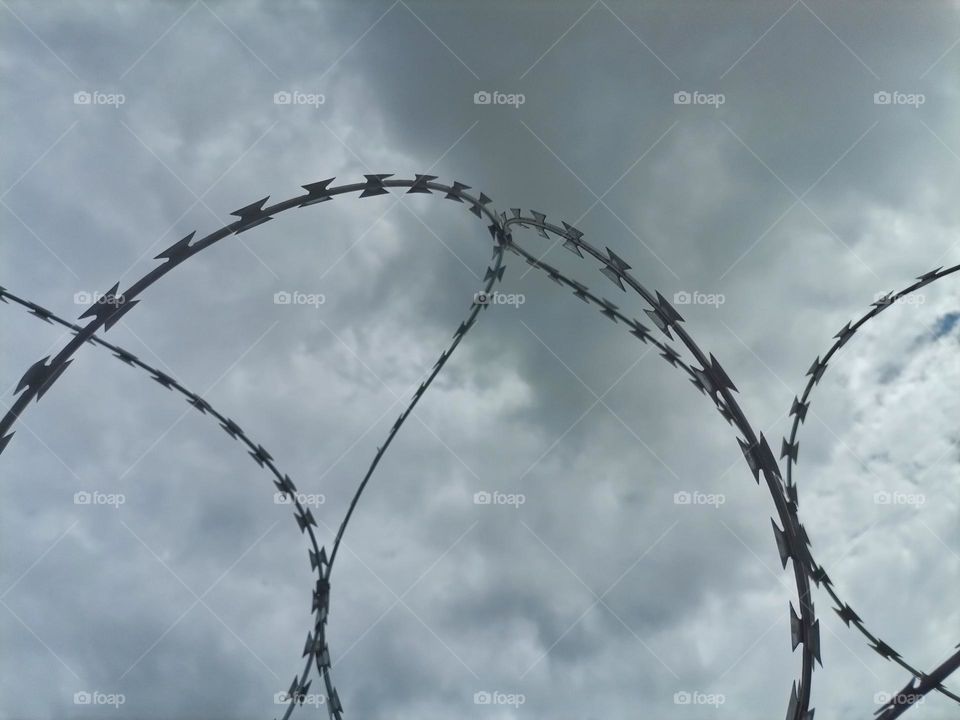 Barbed wire against a dark cloudy sky
