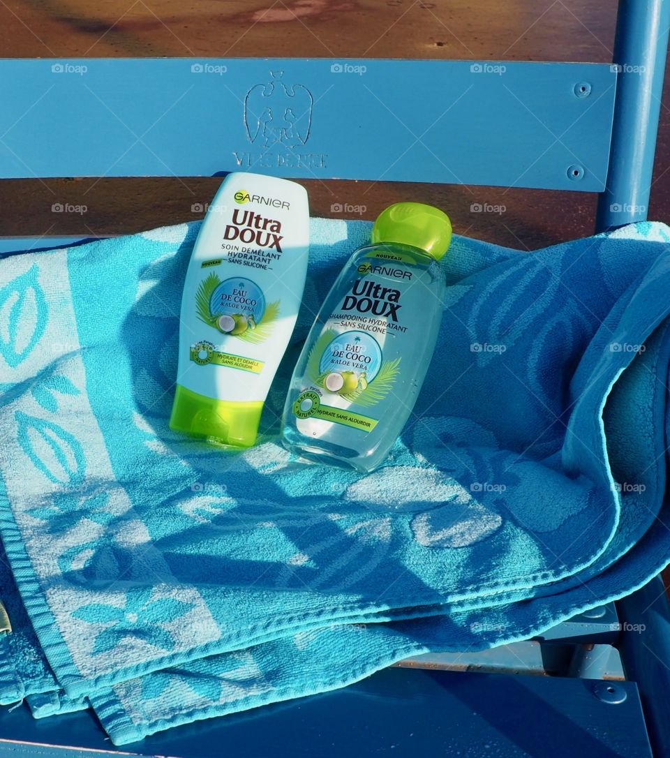 Garnier eau de coco on blue beach towel on blue chair in Nice, France.