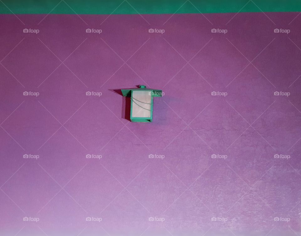 Purple wall with a light that almost looks like a lantern