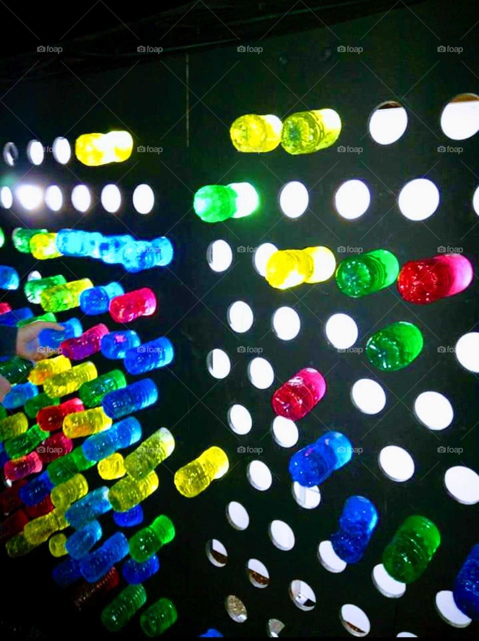 Life size lite brite wall .water bottles filled with bright colors .