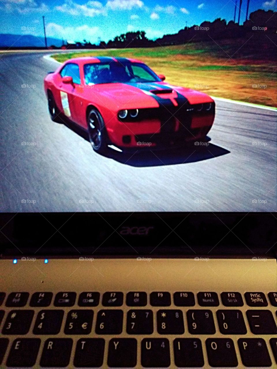 Red muscle car racing on the laptop screen