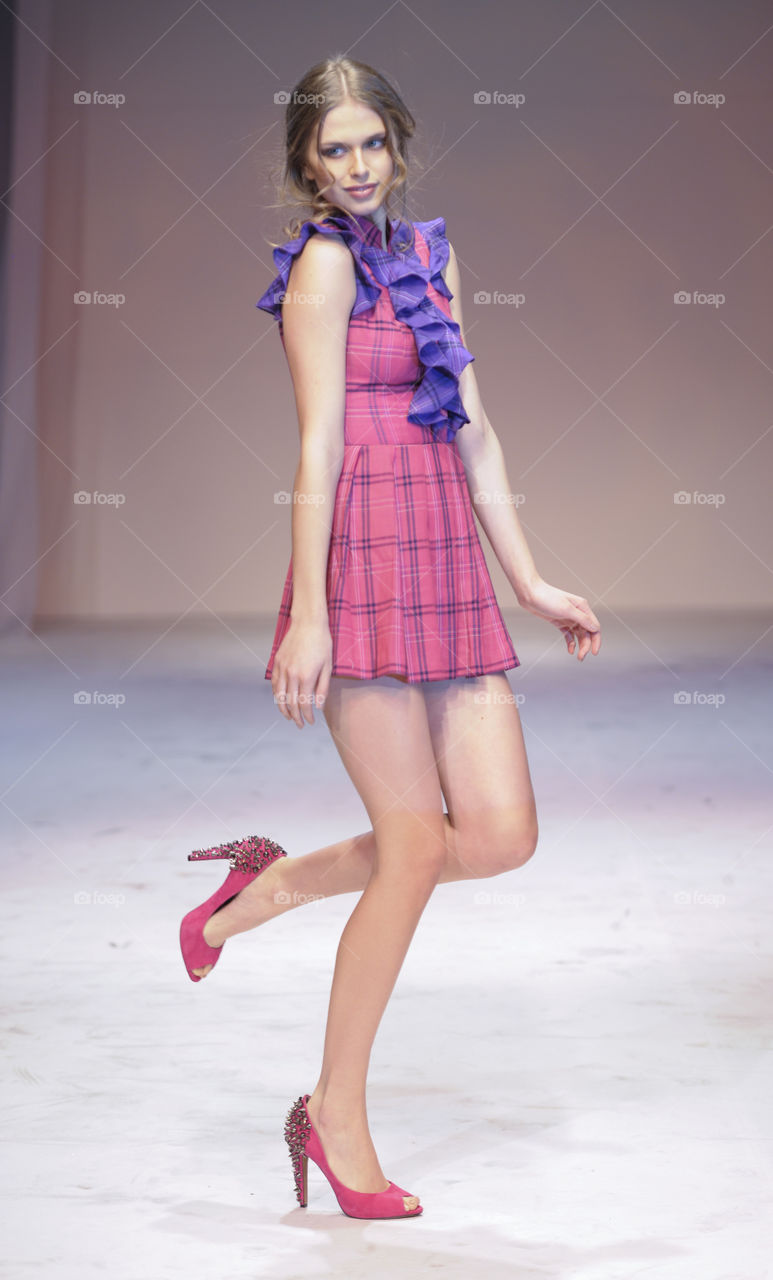 Fashion show runway model in pink dress.