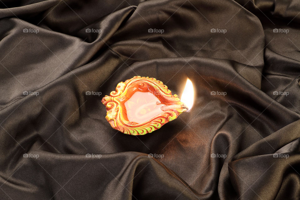 Diwali diya on black satin background