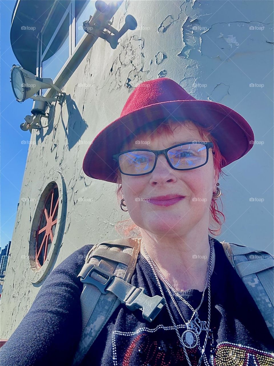 This is me, “Petra Schiller” a.k.a. “Maxine Firefox” standing at the center outpost of the “Pulaski Bridge” at “Newtown Creek” that connects LIC, Queens to “Greenpoint”, Bklyn on a sunny day in April 2024. Hypnotic Productions