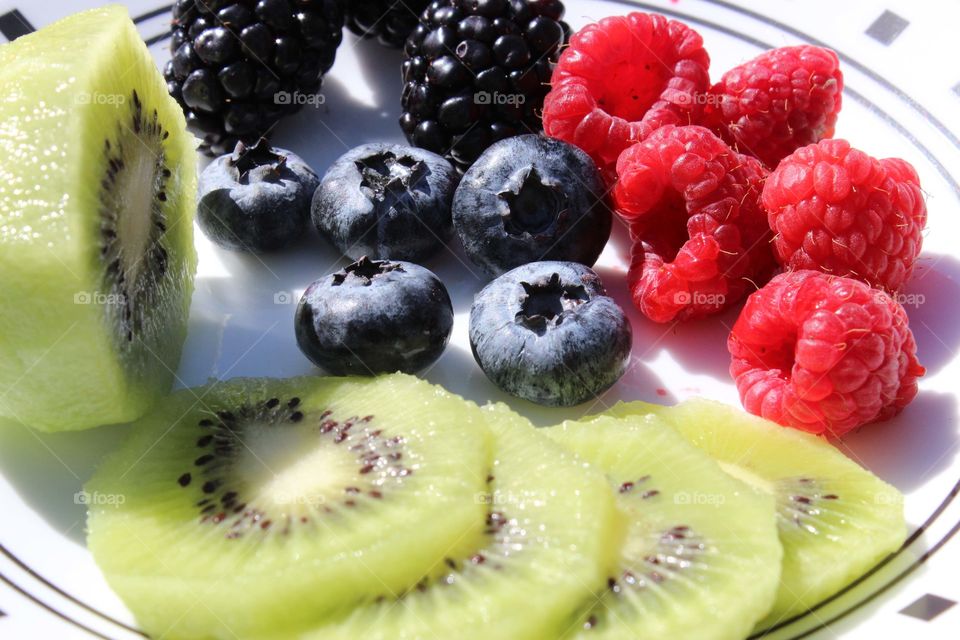 Kiwi and fresh berries in plate