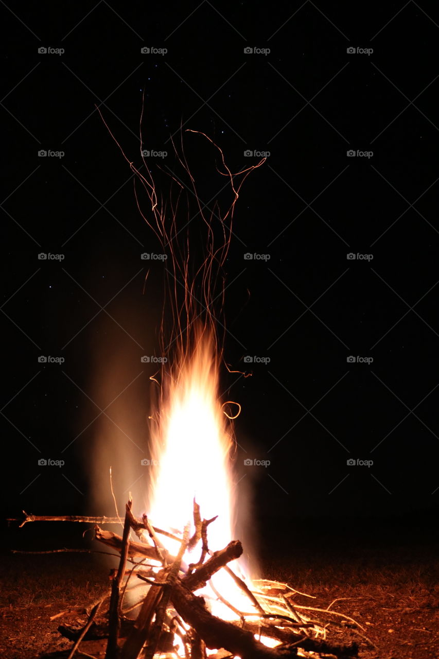 A burning fire out in the wild of the woods.