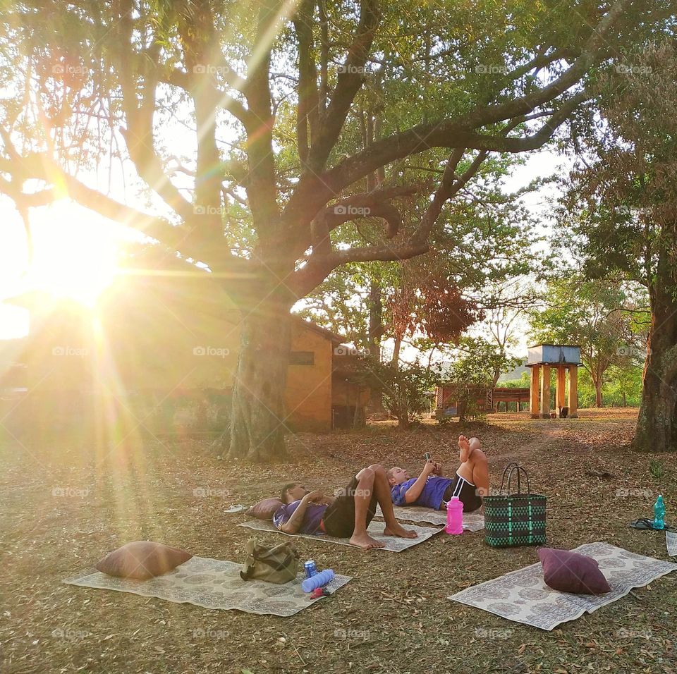 A picnic is always a delicious way to enjoy life with friends outdoors, in the shade of leafy trees... Lying on mattresses on the grass, with pillows scattered on the ground... In the background, the privilege of a beautiful sunset sun sun!