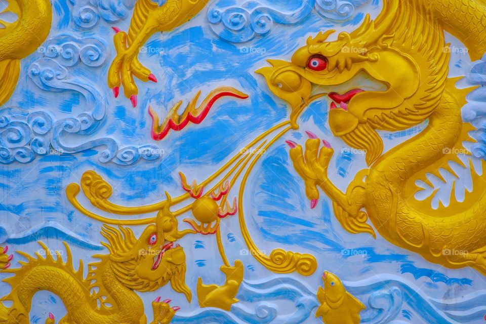 Plaster wall picture with golden dragon pattern The image is suitable for use as a background.