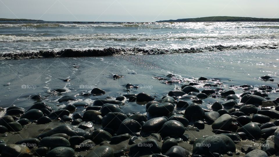Black sandy beach with rocks